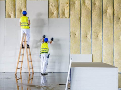 Men-putting-up-drywall