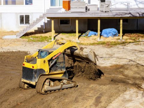 Mini bulldozer with earth doing landscaping works level the ground